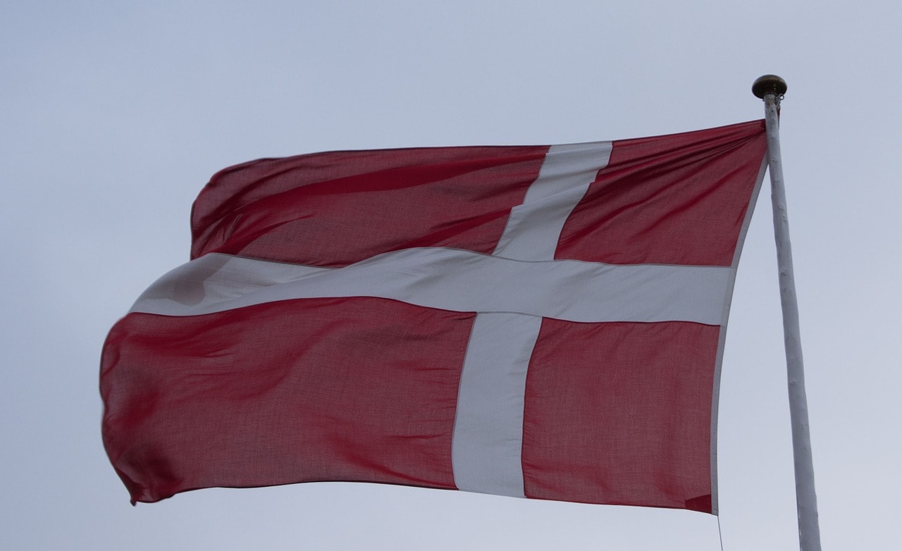 Un vol Danemark pas cher avec Algofly illustré par le drapeau national flottant dans les airs.