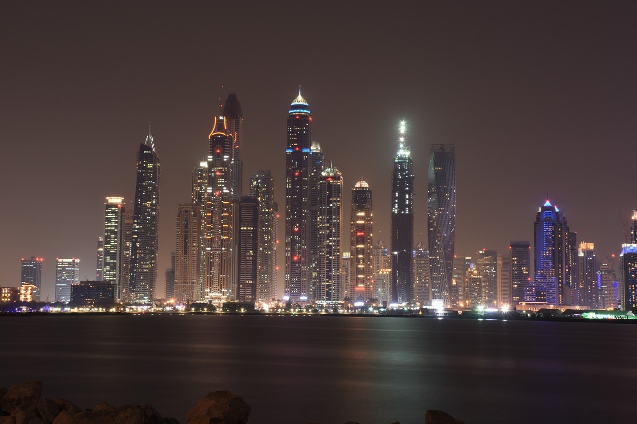 Un vol Dubaï pas cher avec Algofly illustré par la ville illuminée au bord de la baie.