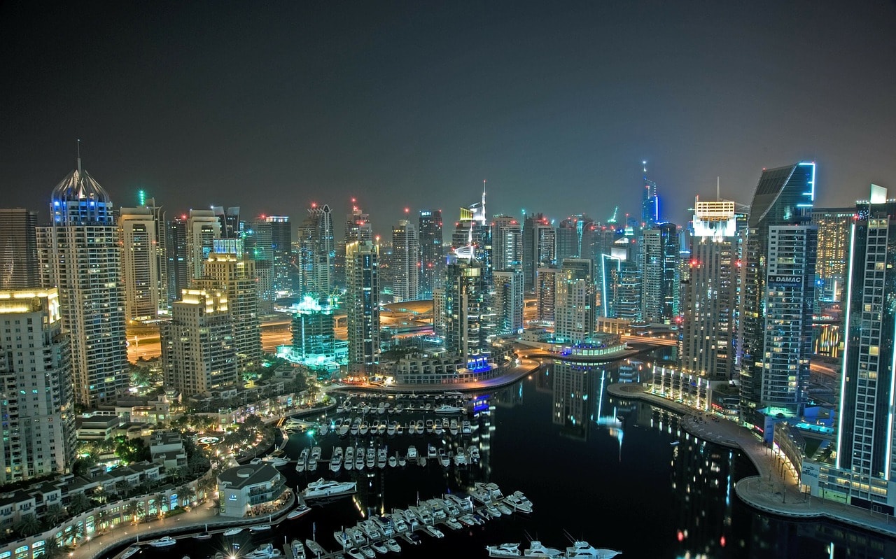 Un vol Emirats Arabes Unis pas cher avec Algofly illustré par les building illuminés autour du port de plaisance de Dubaï.