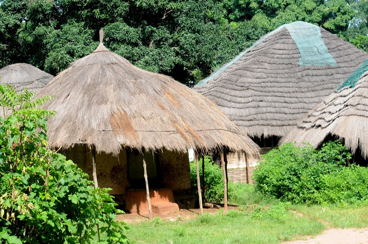 Un vol Guinée pas cher avec Algofly illustré par de typiques cahutes en bois et au toit de paille.