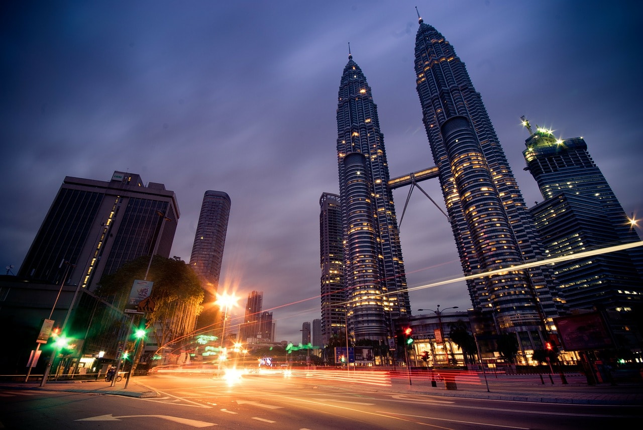 Un vol Kuala Lumpur pas cher avec Algofly illustré par les tours Petronas illuminées dans la nuit.