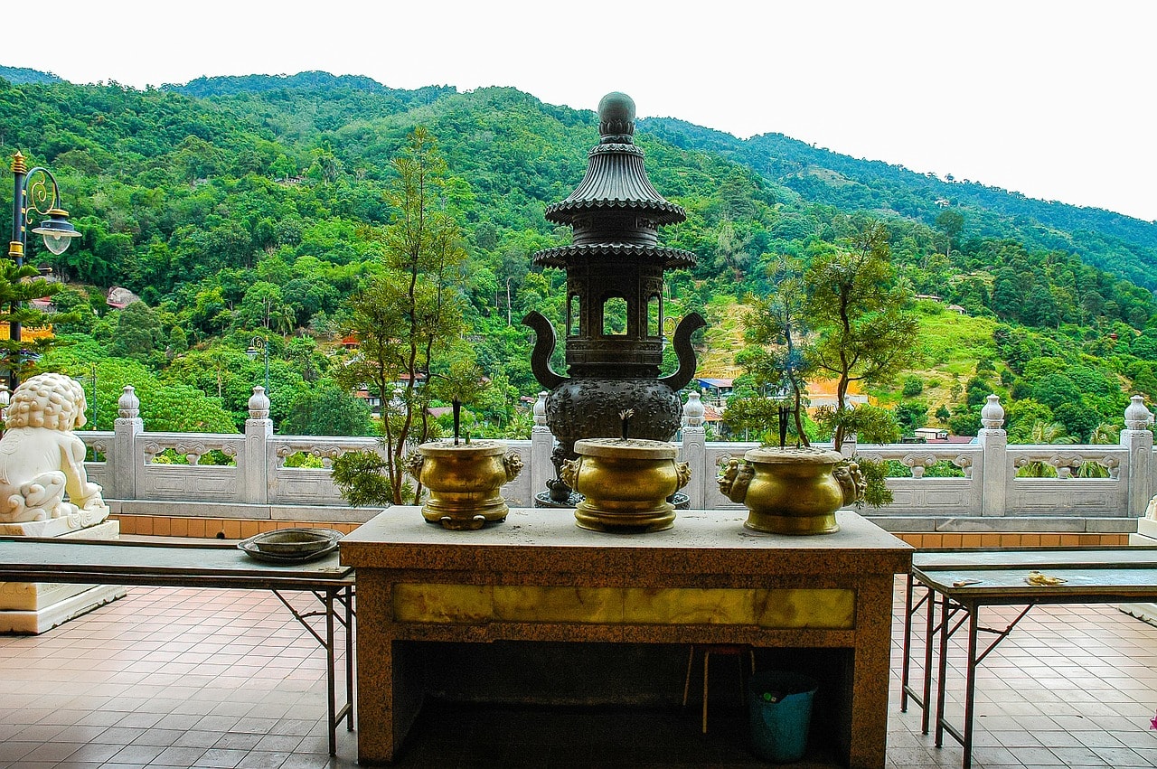 Un vol Malaisie pas cher avec Algofly illustré par la table sacrificielle d'un temple situé en face d'une colline verdoyante.