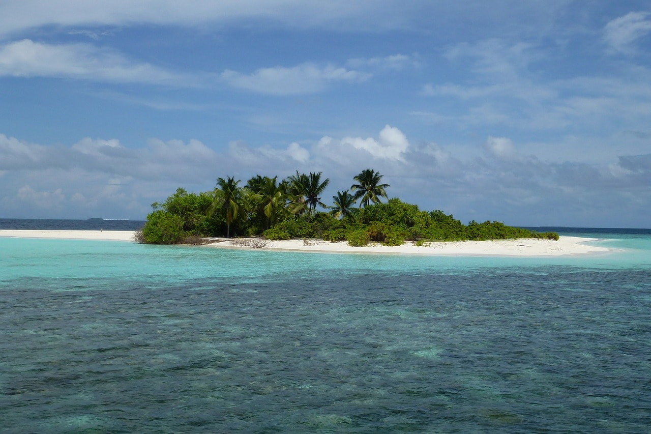 Un vol Maldive pas cher avec Algofly illustré par une île de sable blanc au milieu d'une mer turquoise.