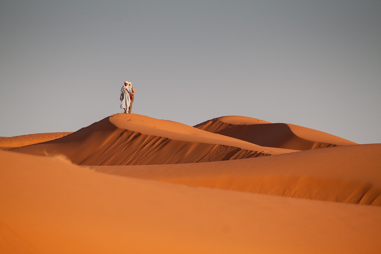 Un vol Maroc pas cher avec Algofly illustré par des dunes orangées.