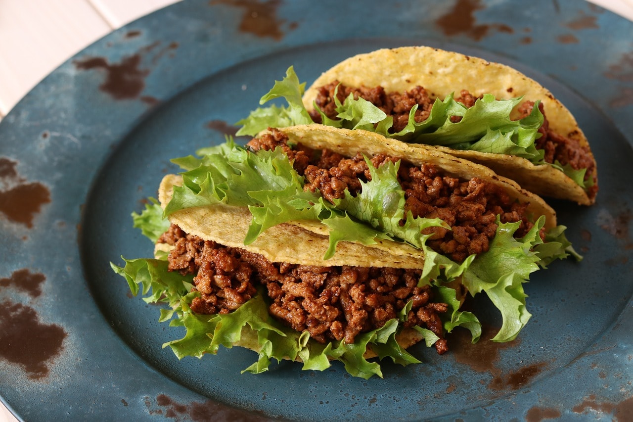 Un vol Mexique pas cher avec Algofly illustré par des tacos de viande hachée et épicée sur une assiette ancienne.