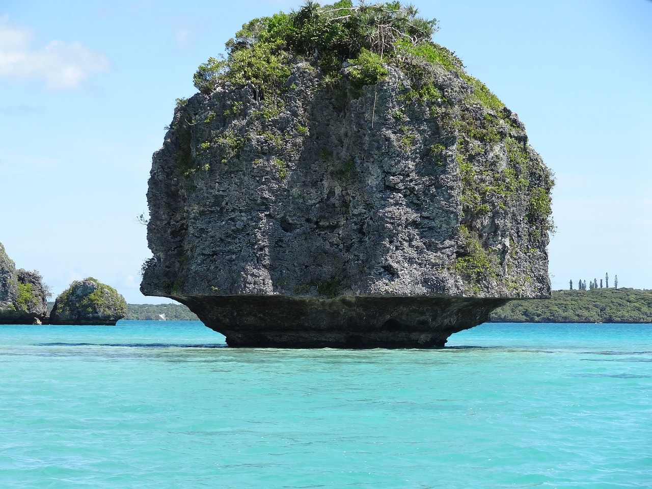 Un vol Nouvelle Calédonie pas cher avec Algofly illustré par les célèbres rochers de l'île des Pins au cœur d'une eau turquoise..