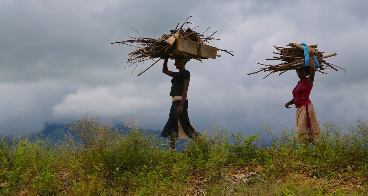 Un vol Ouganda pas cher avec Algofly illustré par deux femmes portant du bois mort sur leur tête.