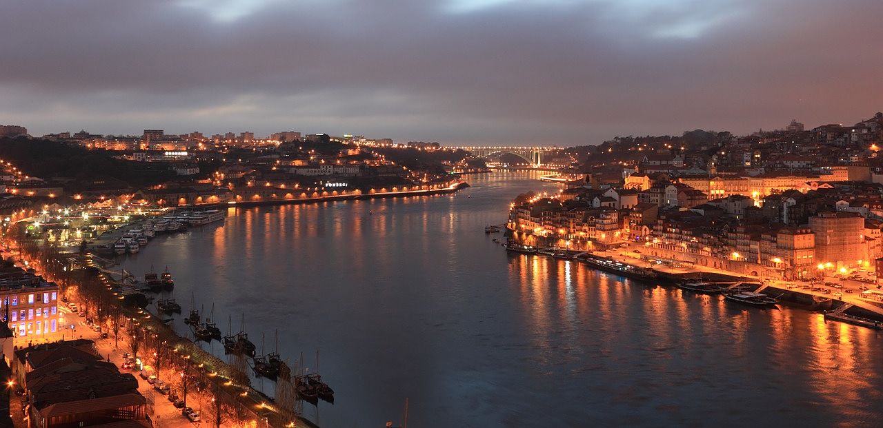 Un vol Porto pas cher avec Algofly illustré par le fleuve Douro traversant la ville illuminée.