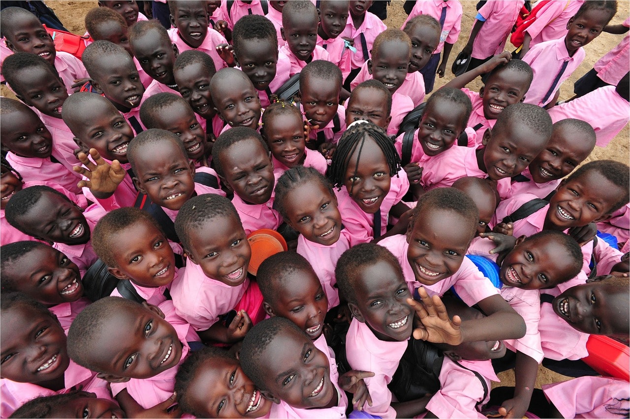 Un vol Soudan pas cher avec Algofly illustré par une foule d'enfant en tenue d'écolier rose.