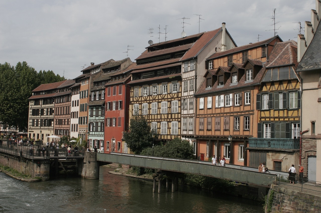Un vol Strasbourg pas cher avec Algofly illustré par des maisons à colombages de couleur jaune, rouge, blanc et orange.