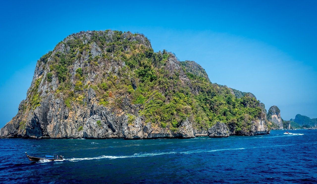 Un vol Thaïlande pas cher avec Algofly illustré par un île rocailleuse jaillissant des eaux.